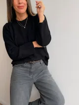 Sweater de punto de diseño minimalista, con cuello redondo y mangas largas. Presenta un corte holgado y textura suave.