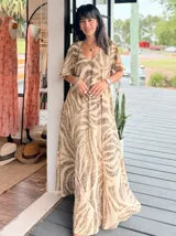 Vestido largo de corte amplio con estampado floral en tonos turquesa, blanco y rosa. Posee escote en V, mangas cortas y espalda con lazo.