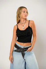 Top negro con breteles finos, escote recto con frunce y corte crop.