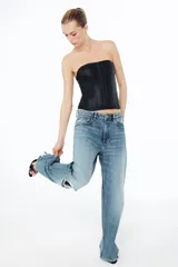 Top tipo corset de escote recto y hombros descubiertos, con cierre frontal mediante ganchos metálicos y costuras verticales estructuradas.