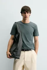 Camiseta de corte ajustado confeccionada en tejido de algodón con elasticidad, cuello redondo y manga corta.