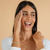 Conjunto compuesto por una cadena fina de eslabones y un dije circular con la imagen de San Benito, ambos realizados en oro 18k.