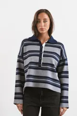 Sweater tipo chomba de tejido bremer con diseño a rayas horizontales en gris y azul marino. Presenta cuello polo, cierre frontal con botones y mangas largas con caída holgada.