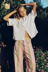 Jeans baggy de tiro medio con diseño de rayas multicolores, bolsillos y cierre frontal con cremallera y botón metálico.