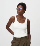 Musculosa básica de canalé color blanco, con escote redondo amplio y breteres anchos, de corte ajustado.