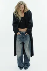 Abrigo largo de corte recto confeccionado en mezcla de lana. Presenta cuello con solapas de muesca, cierre frontal cruzado con doble botonadura y bolsillos laterales de vivo.