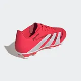 Championes de fútbol Adidas Predator Club, color rojo vibrante con las tres franjas características en plateado. Presentan un exterior sintético con textura Strikeprint y suela para terreno firme/multisuperficie.