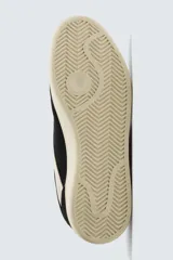 Zapatilla de estilo retro con cordones, confeccionada en una combinación de piezas de gamuza y material sintético. Presenta suela de goma a contraste y diseño de paneles laterales.