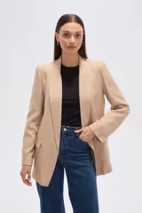 Blazer color beige, de corte holgado, con solapas anchas y bolsillos frontales.