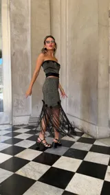 Falda asimétrica de tejido lurex negro y dorado, con pretina elástica y apliques de crochet en el ruedo.