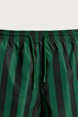Short de baño confeccionado en tejido técnico, con diseño de rayas verticales en color verde y negro. Cuenta con cintura elástica ajustable con cordón, bolsillos laterales y bolsillo trasero con vivo, además de forro interior.