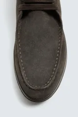 Zapato de cordones con parte superior de piel con acabado en serraje, detalle de bordón en el empeine, horma redonda y suela a contraste.