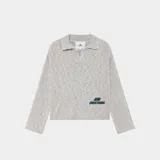 Sweater de punto gris con cuello polo y cierre frontal parcial. Presenta un diseño oversize y logo bordado en el frente.