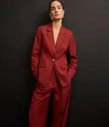 Pantalón de vestir color borgoña, de corte zanahoria, con pliegues delanteros, cierre con solapa y cremallera oculta.