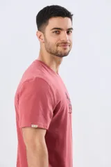 Remera Legacy de manga corta y cuello redondo, color azul melange, con estampa frontal y detalles bordados de un vehículo todoterreno acompañados por el texto "The Adventure Club".