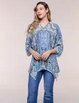 Blusa holgada de poliéster con estampado de arabescos en tonos azules, escote en V con botones frontales, mangas 3/4 y ruedo asimétrico en punta.