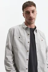 Camisa manga larga color verde oliva, corte slim fit, con cartera abotonada, dos bolsillos frontales con botón y confeccionada en 100% algodón.