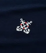 Remera azul marino de viscosa con cuello redondo y mangas cortas. Presenta un bordado con motivos marineros en el frente. Corte regular.