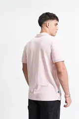 Remera polo clásica color rosado, con bolsillo frontal y calce regular.