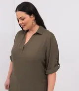 Vestido tipo chemise corto de color verde militar, con escote en V, cuello camisero, mangas 3/4 con detalle de trabilla y bolsillos laterales.