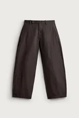 Pantalón barrel fit de corte ancho color marrón, confeccionado en mezcla de algodón y lino. Presenta bolsillos frontales, bolsillos traseros de vivo y cierre frontal con cremallera y botón.