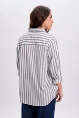 Camisa casual de manga larga con diseño de rayas verticales, cuello camisero y cierre frontal de botones.