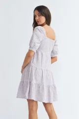 Vestido corto de algodón con estampado de cuadros vichy en color lila y blanco, escote corazón, mangas cortas abullonadas y falda escalonada con volantes.