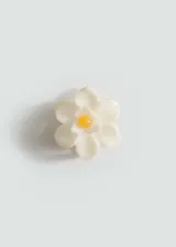 Broche para el pelo con diseño de flor en color blanco con centro amarillo.