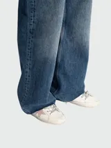 Championes Golden Goose modelo Super Star, de cuero blanco con estrella rosa en el lateral y cordones plateados.