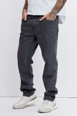 Pantalón de jean corte regular, color gris oscuro, con diseño de cinco bolsillos y cierre frontal con botón y cremallera.