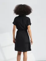 Vestido corto con estampado animal print tipo cebra en tonos blanco y negro. Presenta escote en V, mangas cortas y un lazo ajustable en la cintura para entallar la silueta.