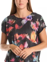 Remera de manga corta con frente estampado con diseño floral multicolor sobre fondo negro y espalda lisa. Presenta cuello redondo a la base y corte recto.