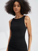 Vestido midi negro sin mangas, de corte ajustado con frunces laterales y abertura alta en la pierna.