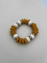 Set de tres pulseras elásticas con cuentas de madera en colores celeste, negro y rosa, con detalles de cuentas doradas y cuentas color crema.