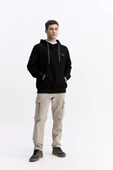 Canguro con capucha y cordones ajustables, de corte holgado y bolsillo frontal tipo canguro. Presenta un pequeño logo estampado en el pecho.