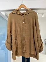 Camisa tostada de lino con cuello camisero, cierre frontal de botones, bolsillos aplicados en el frente y mangas largas con presilla para arremangar.