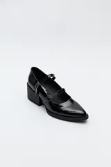 Zueco estilo Mary Jane color negro charol, con doble tira y hebillas metálicas. Presenta punta cuadrada y taco ancho de altura media.