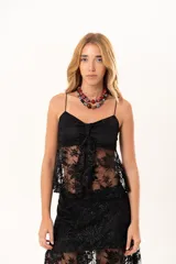 Top de encaje negro con breteles finos, diseño con detalle fruncido en el escote y apertura frontal con nudo decorativo.