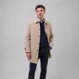 Gabardina impermeable color beige con cierre frontal de botones, cuello clásico y ajuste en las mangas. Cuenta con interior forrado a cuadros y bolsillos internos.