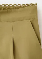 Short de tiro medio color verde militar, con pinzas, bolsillos laterales y delicados detalles bordados calados en el ruedo.