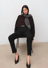 Pantalón negro de corte recto y tiro medio, con trabillas para cinturón.