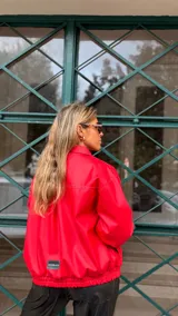 Campera de cuero sintético color rojo, con cierre frontal, cuello camisero y puños elásticos.