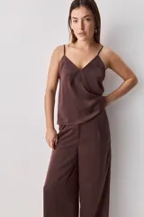 Pantalón wide leg de tiro medio y calce amplio, color marrón, con pinzas delanteras, cierre frontal y bolsillos laterales funcionales.