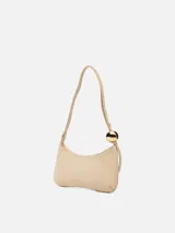 Bolso tipo baguette Jacquemus modelo Le Bisou Perle, de cuero con efecto cocodrilo en color beige. Presenta una correa delgada ajustable con dos esferas metálicas doradas decorativas y el logotipo de la marca en letras doradas en el frente.