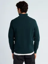 Sweater de punto color verde oscuro, con cuello alto y cierre frontal parcial, de manga larga y puños acanalados.