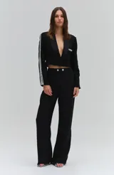 Pantalón de corte recto y tiro medio color blanco, confeccionado en crepé. Cuenta con trabillas en la cintura y cierre frontal adornado con dos botones joya.
