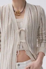 Sacón largo de tejido de punto con rayas verticales en tonos azul, rosa, amarillo y negro. Tiene mangas largas, cuello en V y cierre frontal con lazos.