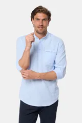 Camisa celeste de lino y algodón, de manga larga, corte slim, con cuello mao, medio abotonada y bolsillo en el pecho.