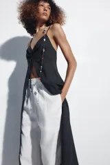Top largo confeccionado en lino, color negro, con tirantes finos, escote en V con encaje y detalle de frunces y lazada frontal.
