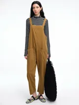 Mono largo de pana color verde oscuro, con breteles finos y silueta relajada de pierna amplia.